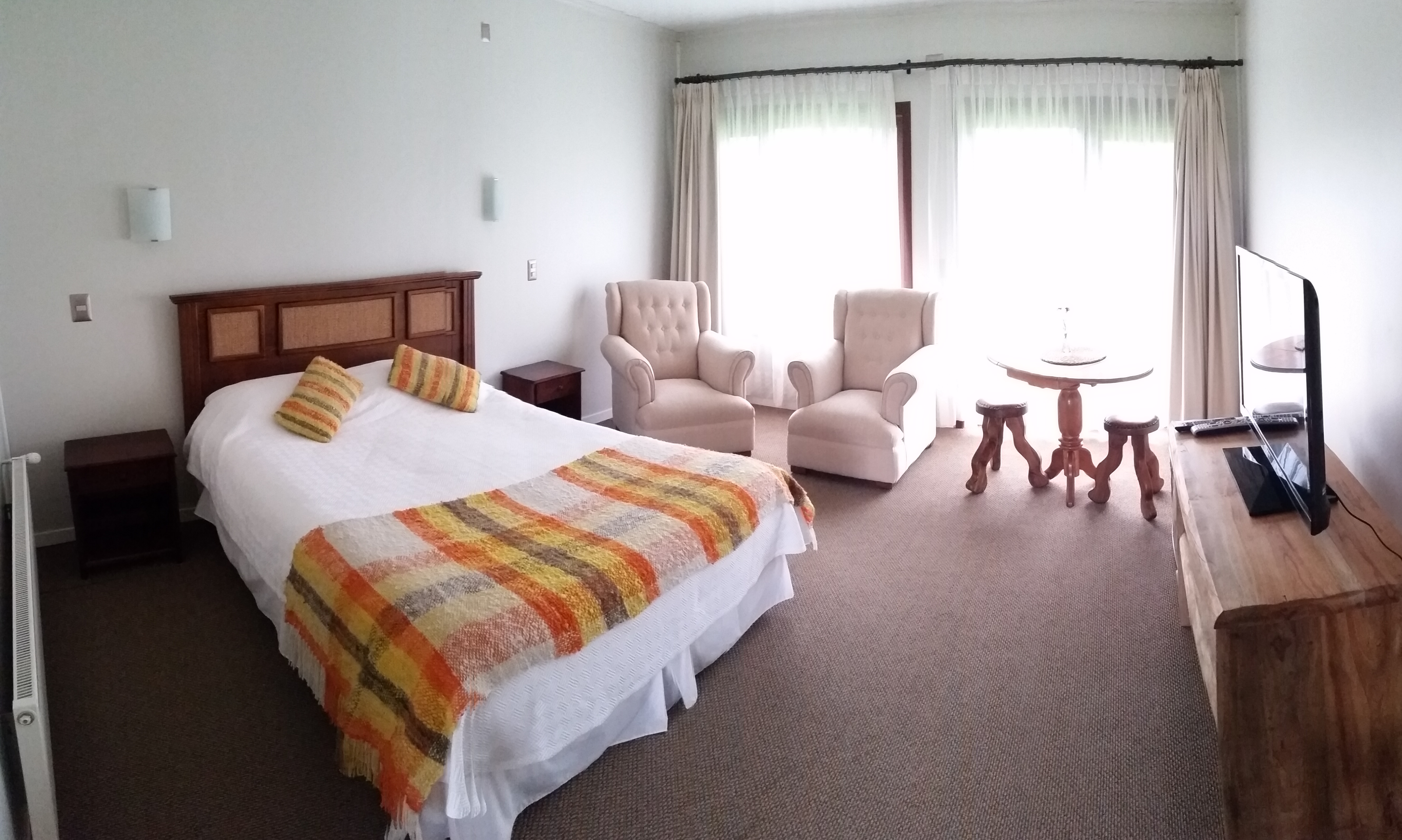 Habitación matrimonial panorámica con sillones en Termas Llifén