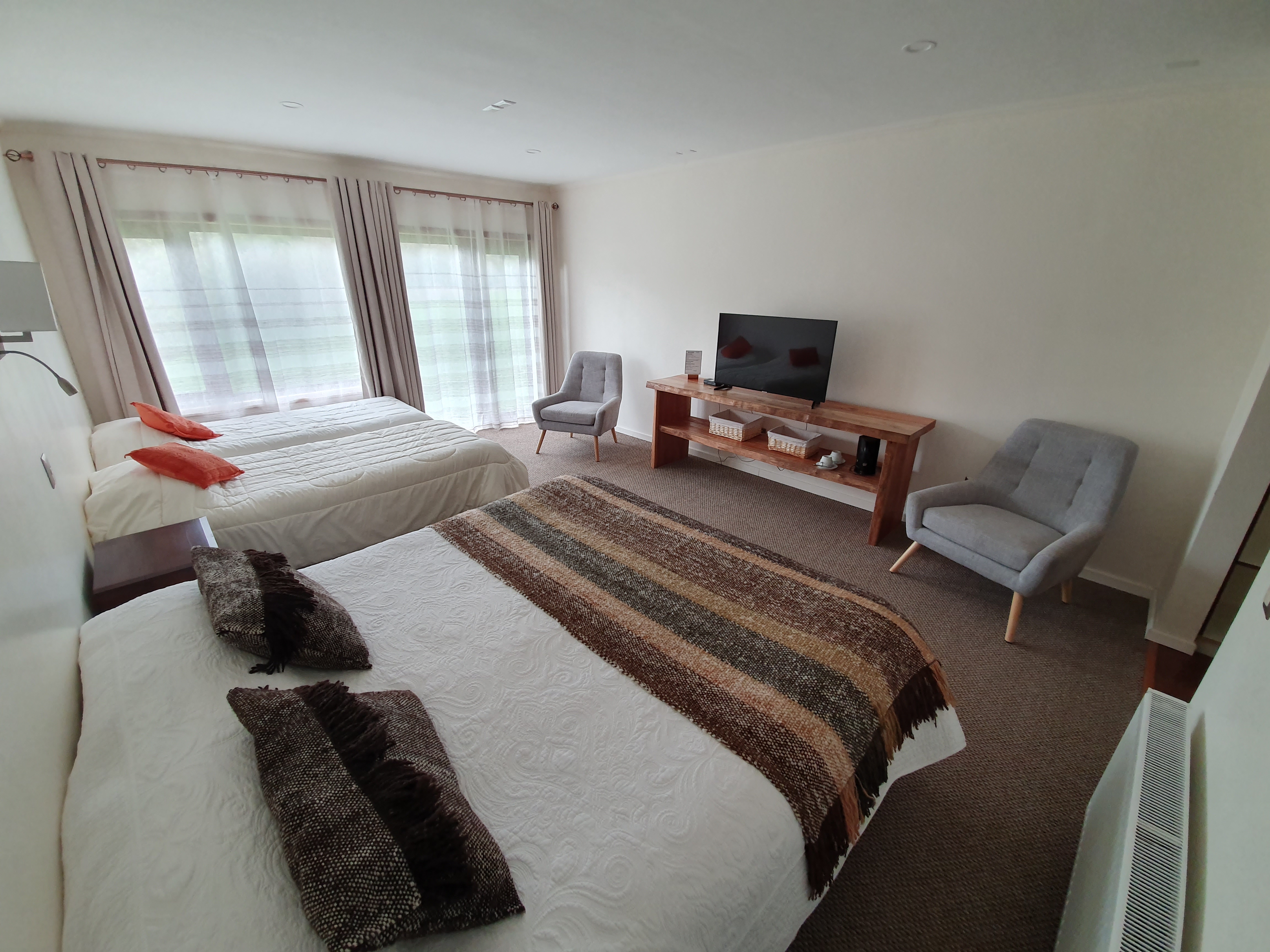 Habitación suite con dos camas, TV y sillones en Termas Llifén